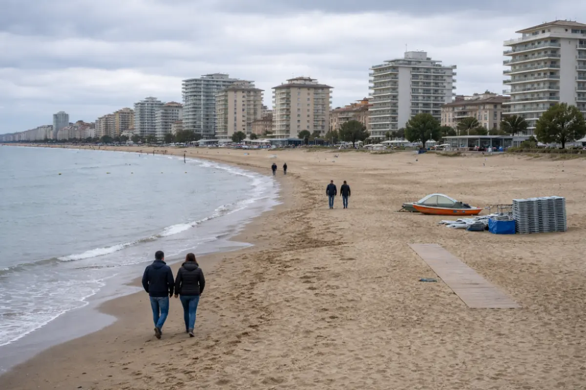 Spiaggia della Riviera Romagnola quasi vuota con cielo nuvoloso e persone con giacca durante Pasqua